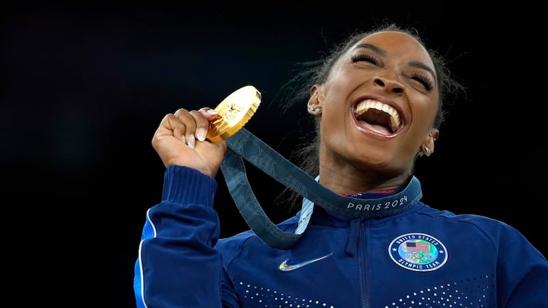 FILE - Simone Biles, of the United States, celebrates after winning the gold medal at the...