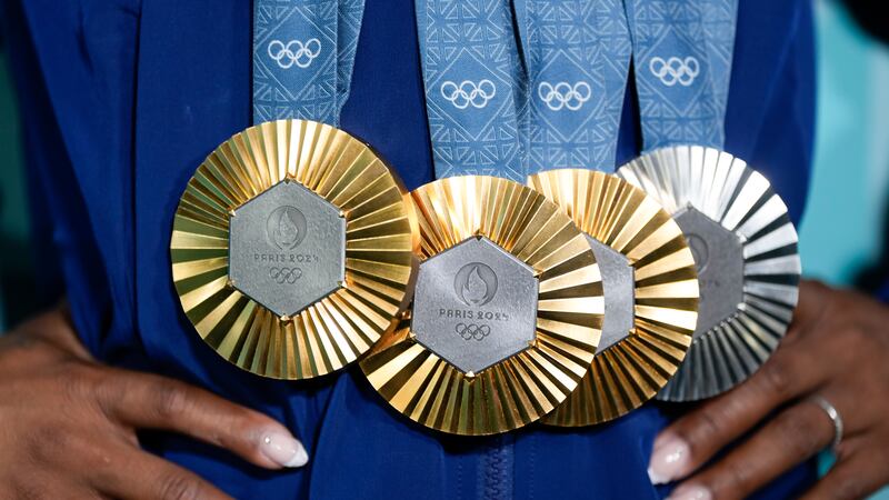 Simone Biles, of the United States, holds up her medals after the women's artistic gymnastics...