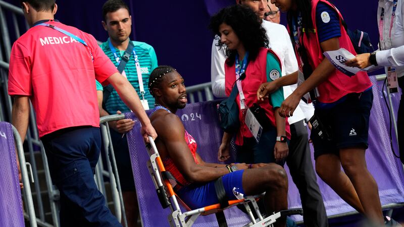 Noah Lyles, of the United States, is taken from the track following the men's 200-meters final...