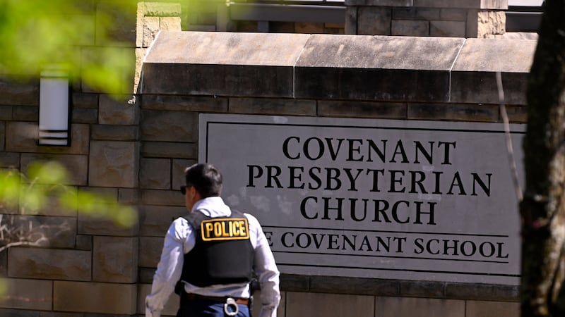 A police officer walks by an entrance to The Covenant School after a shooting in Nashville,...