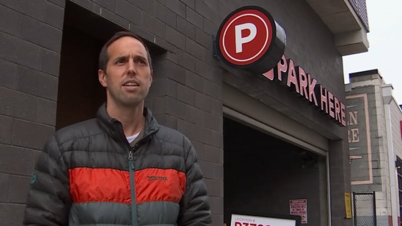 Jared Hill stands in front of Premium garage on Division Street to discuss the high fine he...