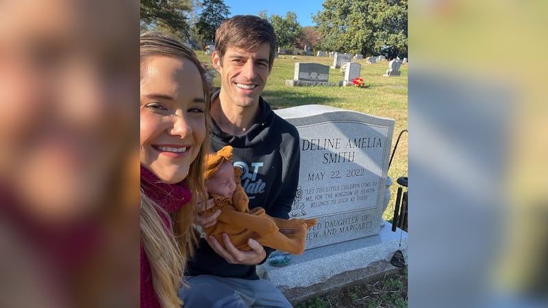 Matt and Margaret Smith, with their daughter Savannah Lindy, stand at the gravesite of their...