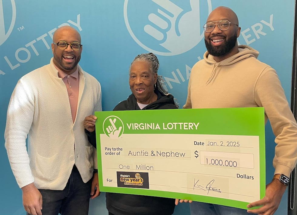 Virginia Lottery Executive Director Khalid Jones (left) presents the $1 million check to...