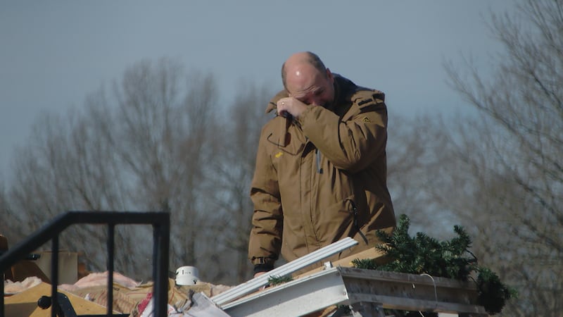 Clarksville School of Fine Arts Director Gabriel Huff tears up as he sifts through remains of...