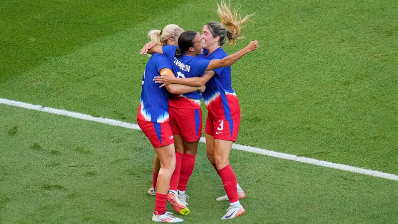 Mallory Swanson, of the United States, center, celebrates with teammates after scoring her...