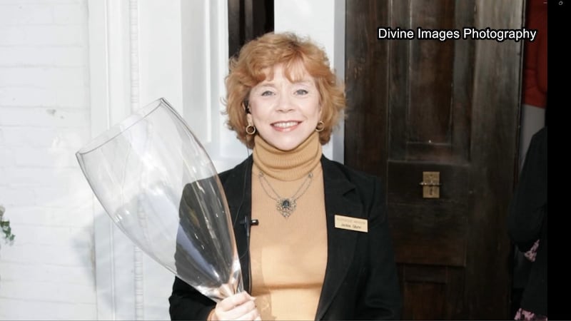 Jackie Glynn hold glass at event