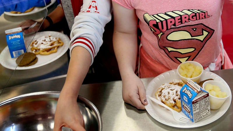 FILE - Students line up for lunch at a middle school in Sandy, Utah, May 19, 2017.