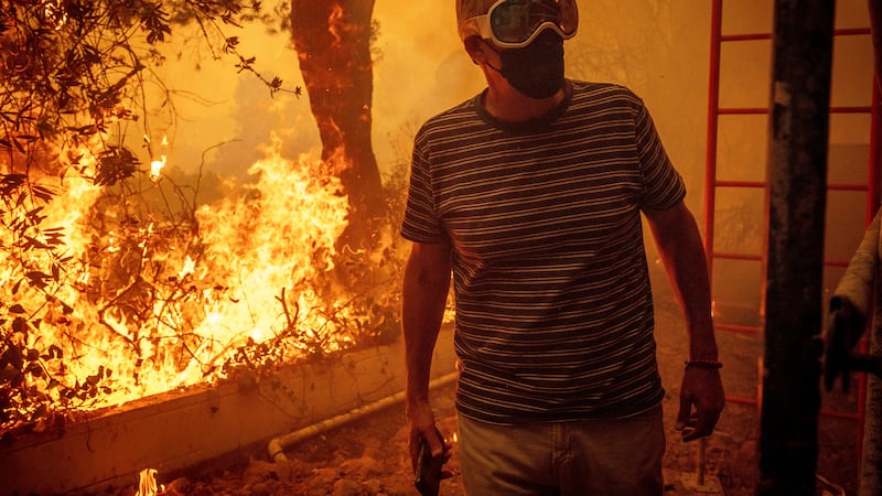 Will Adams watches as flames from the Palisades Fire close in on his property in the Pacific...