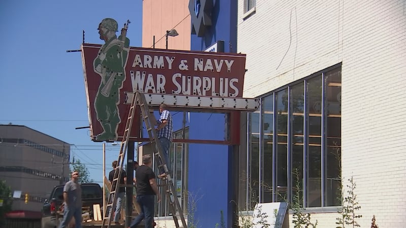 A team takes down the neon sign outside of Friedman's Surplus in Hillsboro Village ahead of...