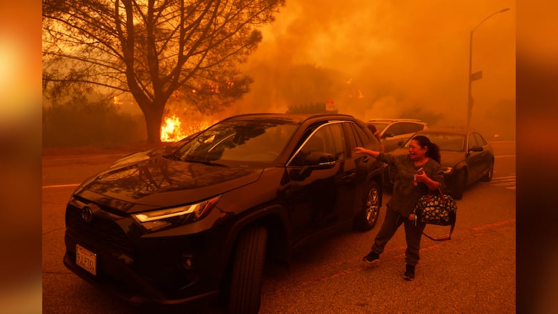 A woman cries as the Palisades Fire advances in the Pacific Palisades neighborhood of Los...